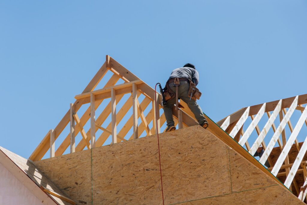Construct wooden roof rafters, and timber beams from the framework of truss frames for a newly