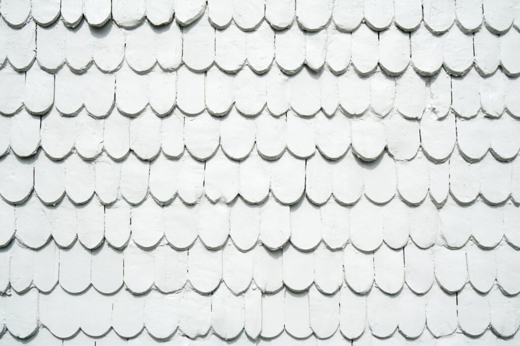 old wooden shingles siding painted white